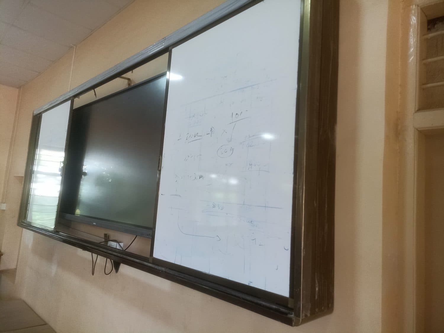 Sliding system flanking a flat panel, college classroom